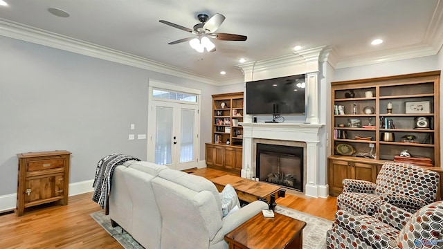 25 Cypress Grove Ln, Huntsville, AL 35824 - living room featuring a glass covered fireplace, a ceiling fan, light wood finished floors, baseboards, and crown molding
