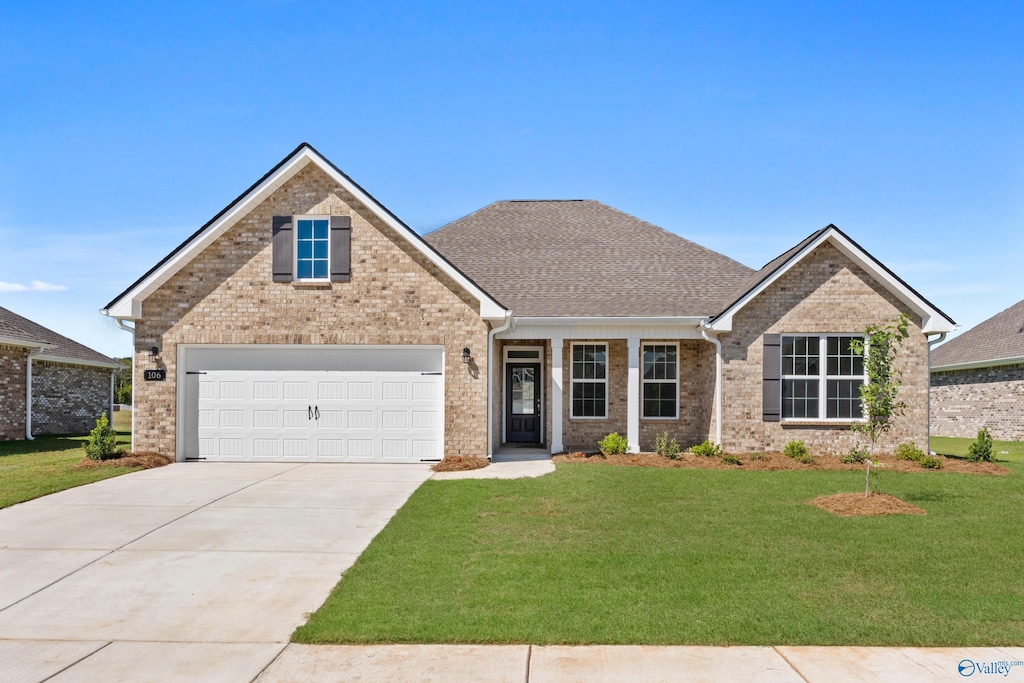 view of front of home with central AC unit, a garage, and a front lawn