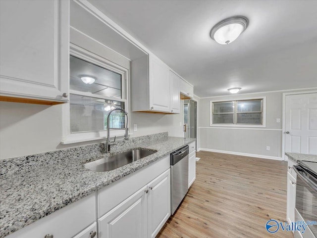 768 County Road 376, Hillsboro, AL 35643 - kitchen featuring stainless steel dishwasher, a sink, white cabinetry, light wood-type flooring, and stove