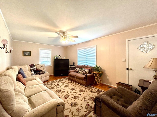 living room featuring wood-type flooring, a textured ceiling, ceiling fan, and ornamental molding