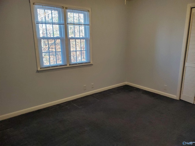 empty room with dark colored carpet