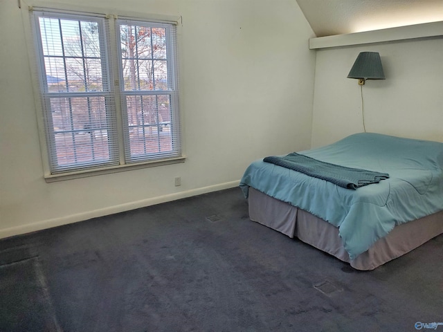 bedroom featuring dark colored carpet and lofted ceiling