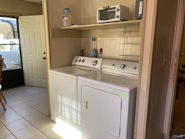 laundry room featuring separate washer and dryer and light tile patterned flooring