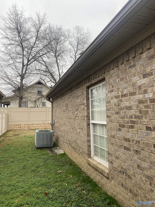 view of home's exterior featuring central air condition unit and a yard