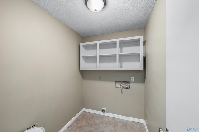 washroom featuring hookup for a washing machine, hookup for an electric dryer, a textured ceiling, and light tile patterned flooring