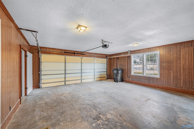 garage with a garage door opener and wood walls