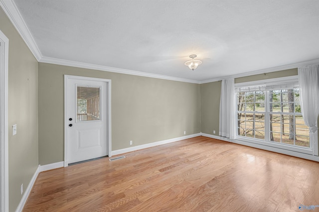 empty room featuring crown molding and light hardwood / wood-style flooring