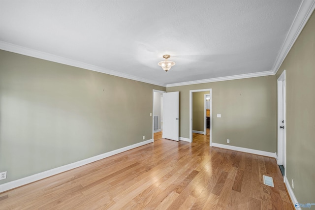 empty room with ornamental molding and light hardwood / wood-style flooring