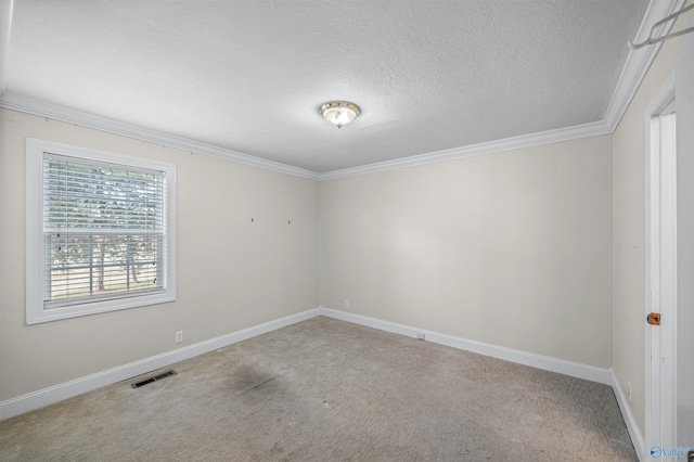 carpeted empty room featuring ornamental molding and a textured ceiling