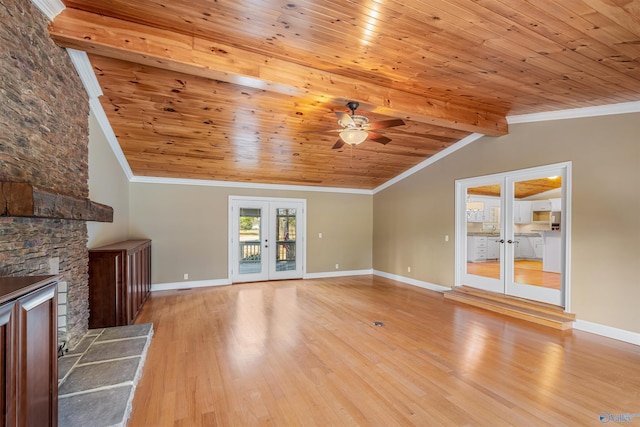 unfurnished living room featuring vaulted ceiling with beams, ornamental molding, light hardwood / wood-style floors, and french doors