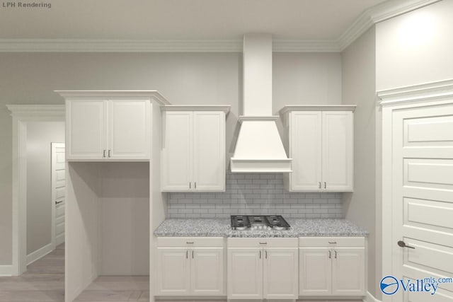 kitchen featuring white cabinets, decorative backsplash, ornamental molding, and light stone counters