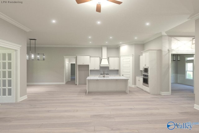 kitchen with an island with sink, ceiling fan, ornamental molding, white cabinetry, and tasteful backsplash