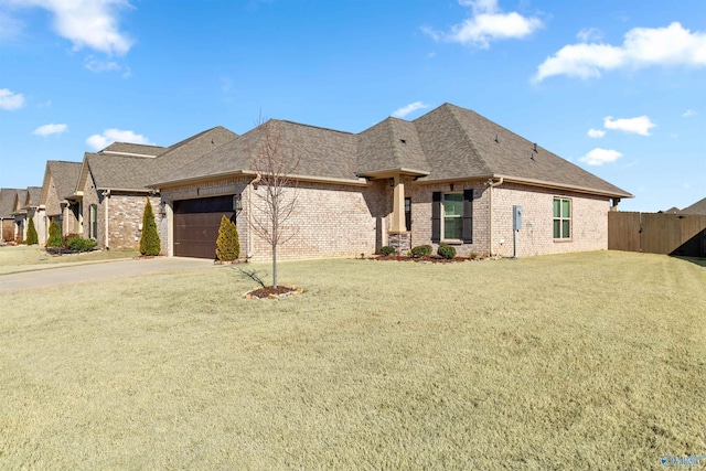 view of front facade featuring a garage, brick siding, a shingled roof, fence, and a front lawn