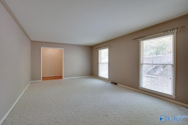 unfurnished room featuring plenty of natural light, light colored carpet, and crown molding