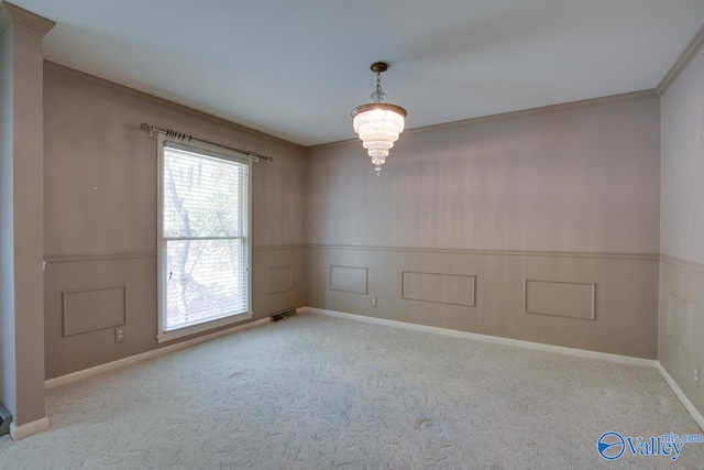 carpeted spare room featuring a notable chandelier and ornamental molding