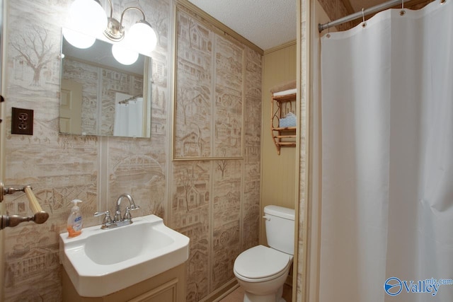 bathroom featuring toilet, curtained shower, sink, and a textured ceiling