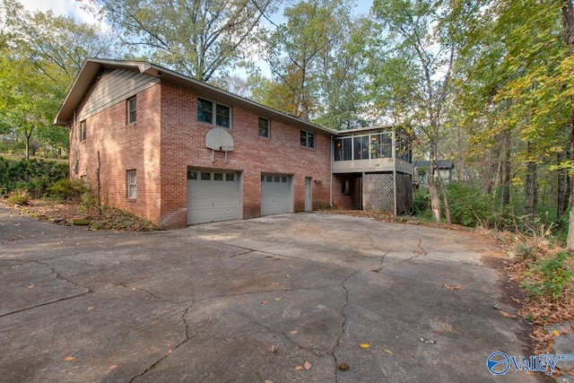 view of side of property featuring a garage and a sunroom