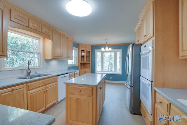 kitchen featuring sink, a center island, tasteful backsplash, pendant lighting, and white appliances