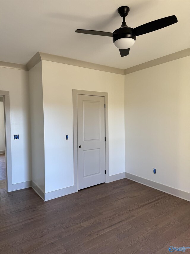 spare room featuring ceiling fan and dark wood-type flooring