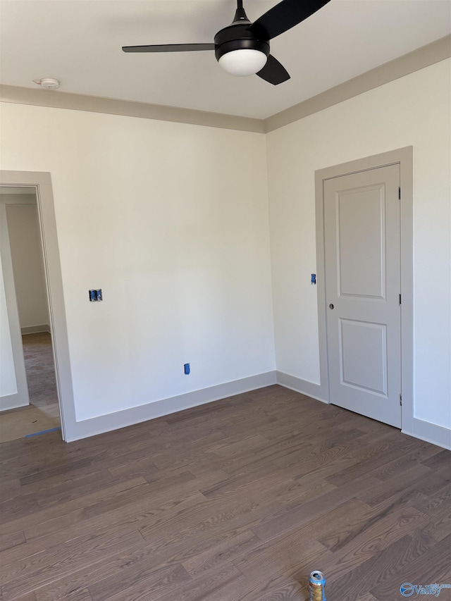 spare room featuring dark wood-type flooring and ceiling fan