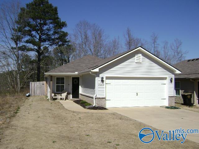 ranch-style house with a garage, concrete driveway, and fence