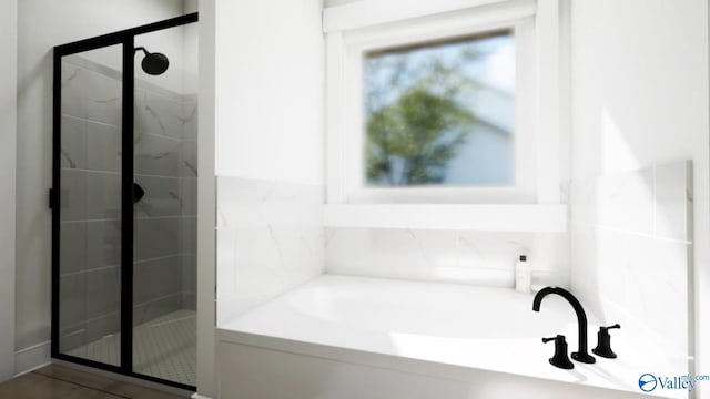 bathroom with a bath and a stall shower