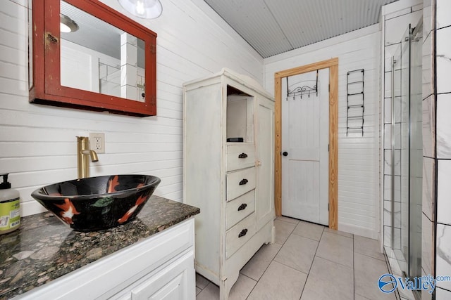 bathroom featuring tile patterned floors, wooden walls, and vanity