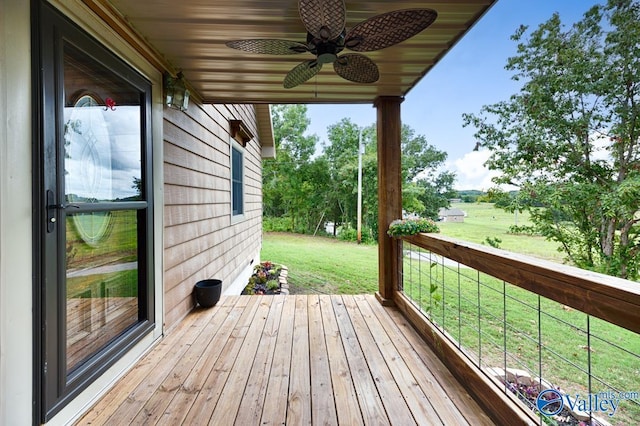 wooden deck with a lawn and ceiling fan