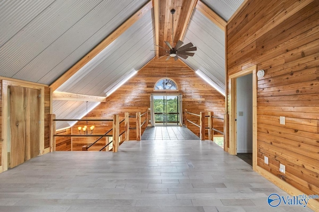 additional living space with beamed ceiling, wooden walls, hardwood / wood-style floors, and a notable chandelier