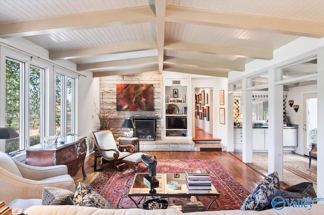 living room with wood-type flooring, vaulted ceiling with beams, and a fireplace