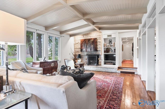 living room with plenty of natural light, a fireplace, hardwood / wood-style floors, and vaulted ceiling with beams