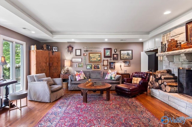 living room featuring hardwood / wood-style flooring and a stone fireplace