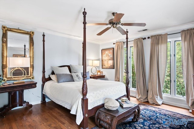 bedroom with crown molding, dark hardwood / wood-style flooring, and multiple windows