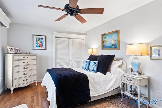 bedroom featuring dark wood-type flooring, ceiling fan, and a closet