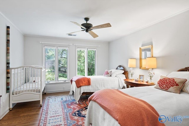 bedroom with dark wood-type flooring, ceiling fan, and ornamental molding