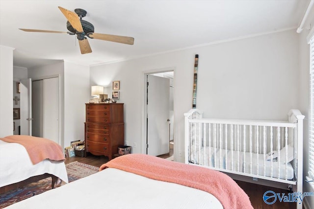 bedroom with hardwood / wood-style flooring, crown molding, ceiling fan, and a closet