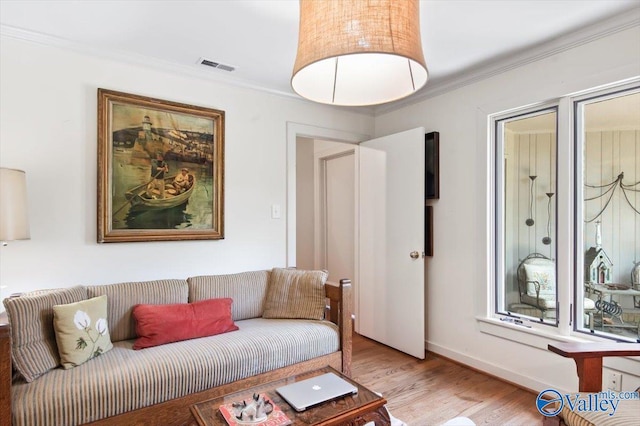 living room with crown molding and light hardwood / wood-style floors