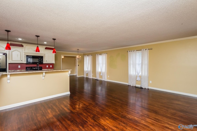 kitchen featuring a breakfast bar, dark hardwood / wood-style floors, black appliances, and white cabinetry