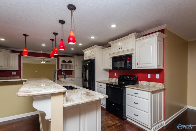 kitchen featuring sink, black appliances, hanging light fixtures, white cabinets, and dark wood-type flooring