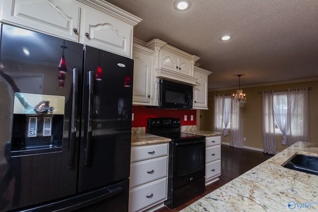 kitchen with white cabinetry, black appliances, ornamental molding, and a notable chandelier