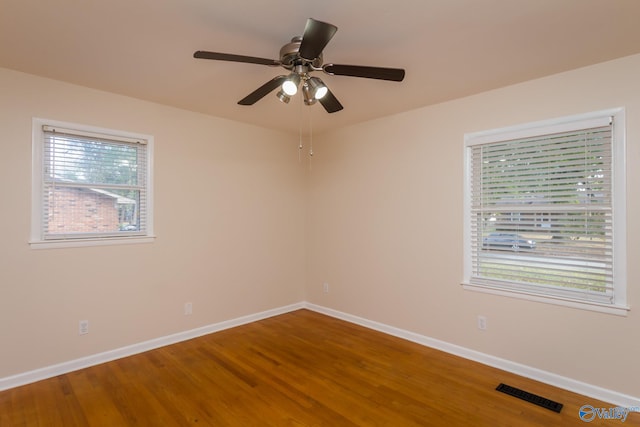 unfurnished room featuring ceiling fan, wood-type flooring, and a healthy amount of sunlight