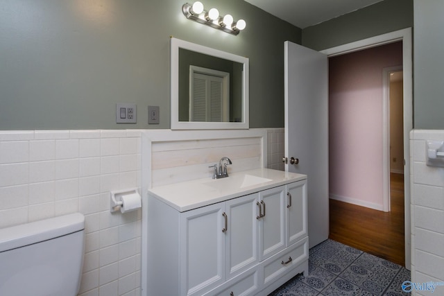 bathroom with hardwood / wood-style floors, vanity, toilet, and tile walls