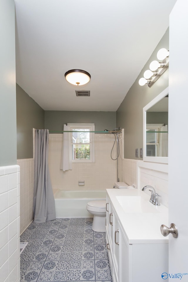 full bathroom with shower / tub combo with curtain, vanity, tile walls, and toilet