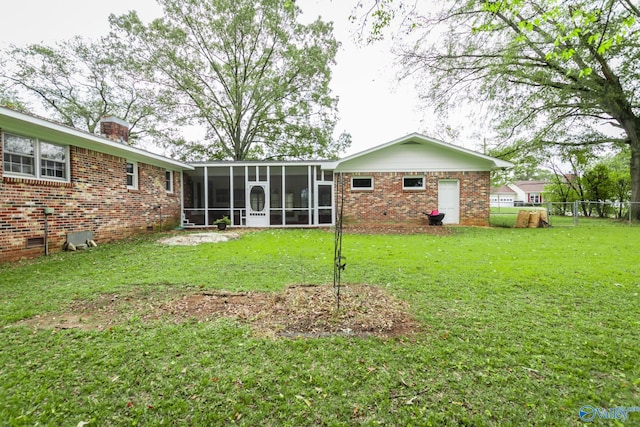 rear view of property featuring a lawn and a sunroom