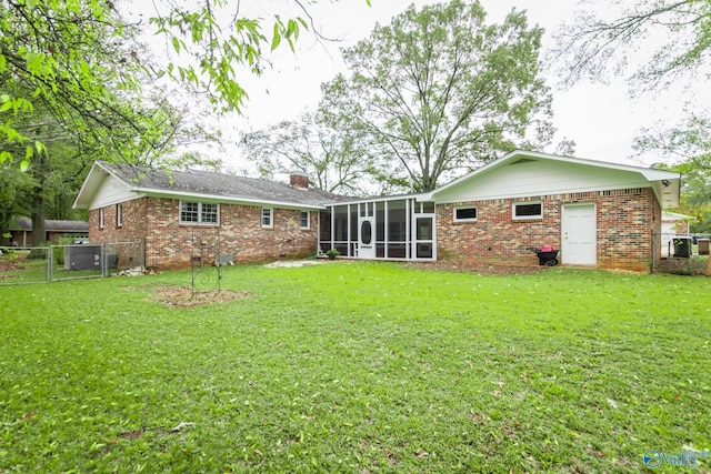 back of property featuring a lawn and a sunroom