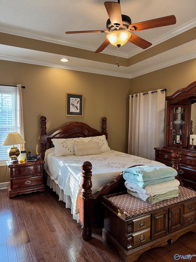 bedroom with a raised ceiling, crown molding, dark hardwood / wood-style flooring, and ceiling fan