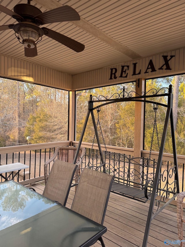 unfurnished sunroom featuring ceiling fan