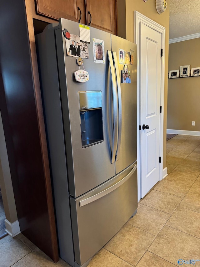 kitchen featuring stainless steel refrigerator with ice dispenser, crown molding, a textured ceiling, and light tile patterned floors