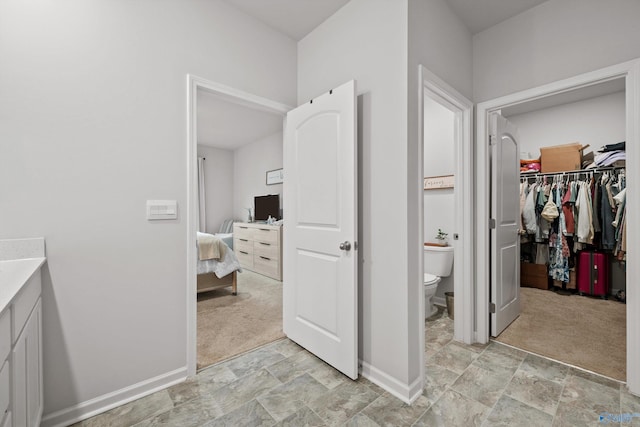 25066 Delilah Cir, Athens, AL 35613 - ensuite bathroom with toilet, ensuite bathroom, baseboards, a spacious closet, and stone finish floor
