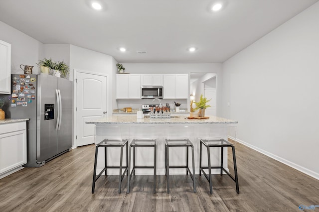 25066 Delilah Cir, Athens, AL 35613 - kitchen with white cabinets, stainless steel appliances, dark wood-style flooring, recessed lighting, and a breakfast bar